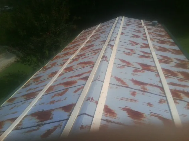 Rusted metal roof panels with new wood purlins before replacement — Storm Damage Roof Repair in Huntland by Roofing Brothers