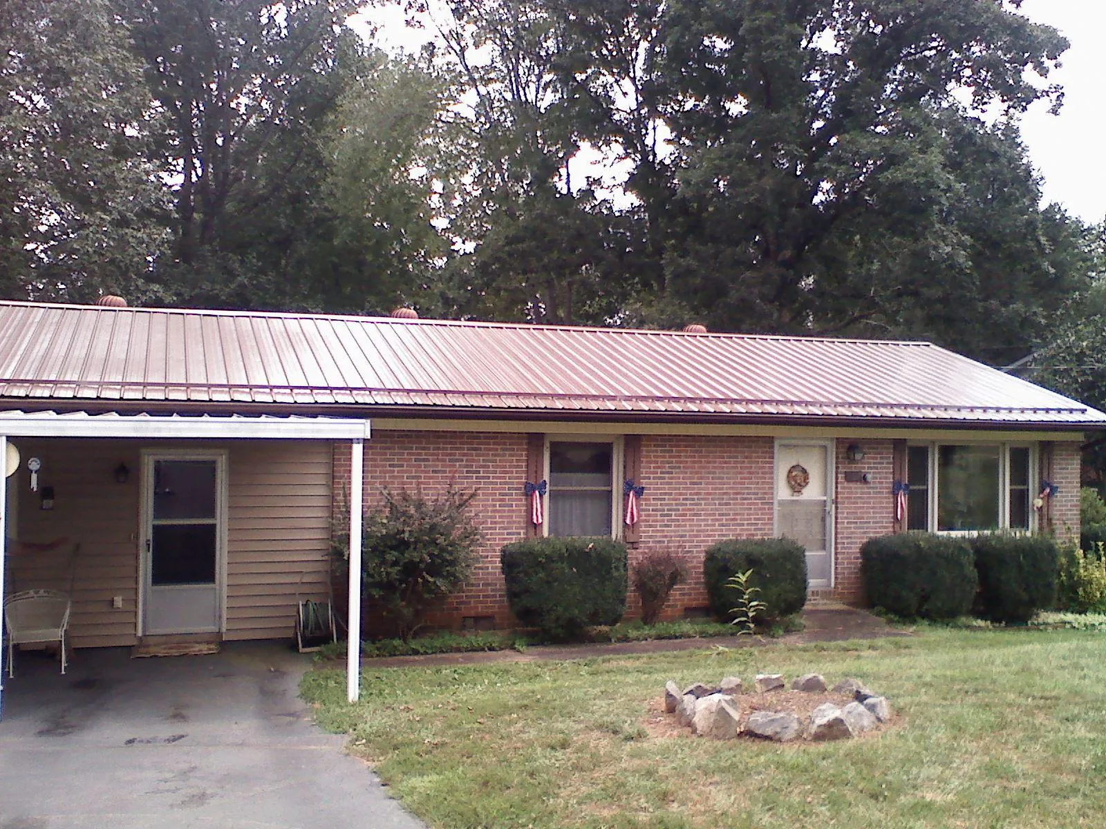 Bronze metal roof and carport on a brick ranch home — Roof Repair work by our crew in Huntland